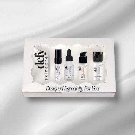 Set of skincare serums in a white gift box with a transparent lid.